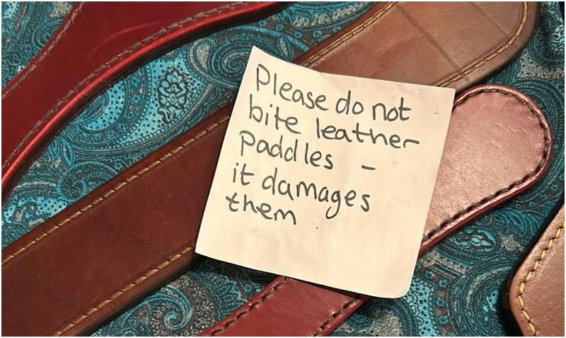 leather spanking implements with a sticky note reminding not to bite them