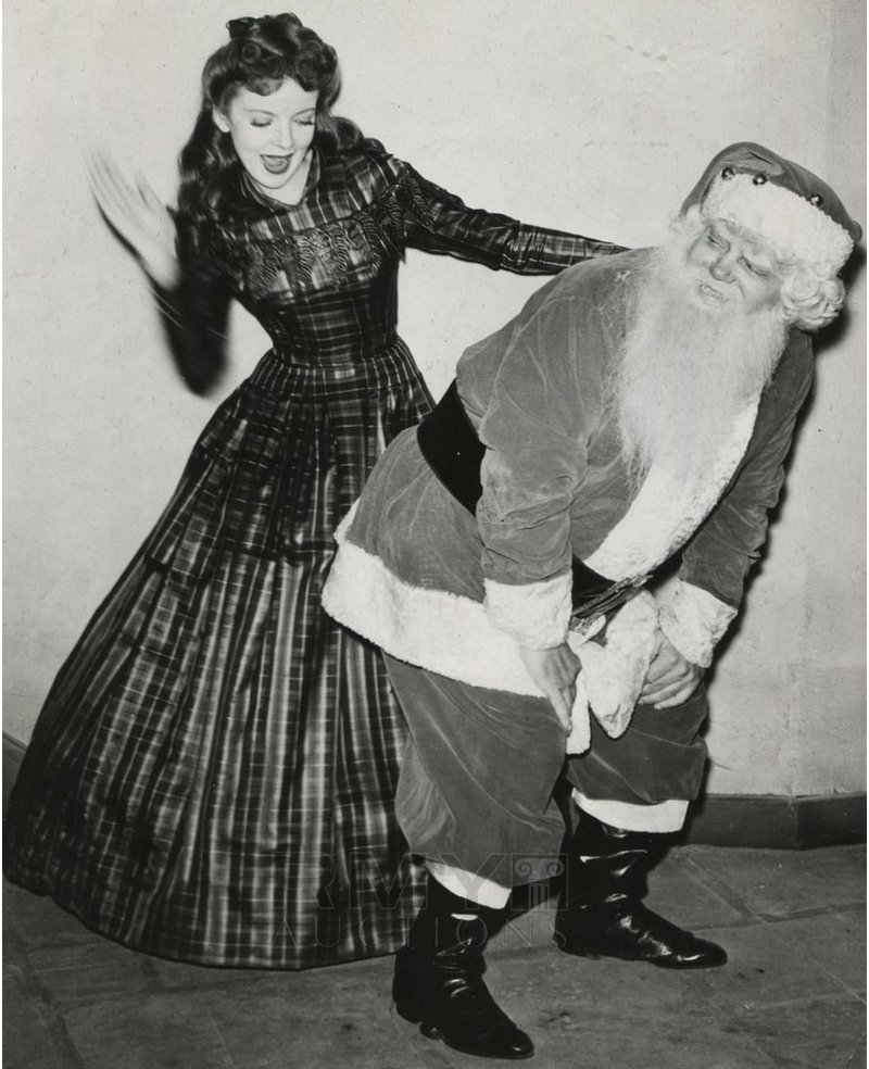 santa gets a spanking from a hollywood actress in full skirts